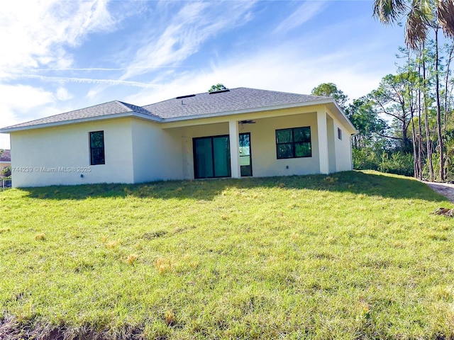 rear view of house featuring a lawn