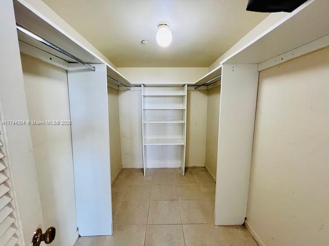 walk in closet with light tile patterned floors