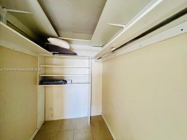 1470 NE 123rd St Unit A707, North Miami, FL 33161 - hallway with light tile patterned floors, elevator, visible vents, and a drop ceiling