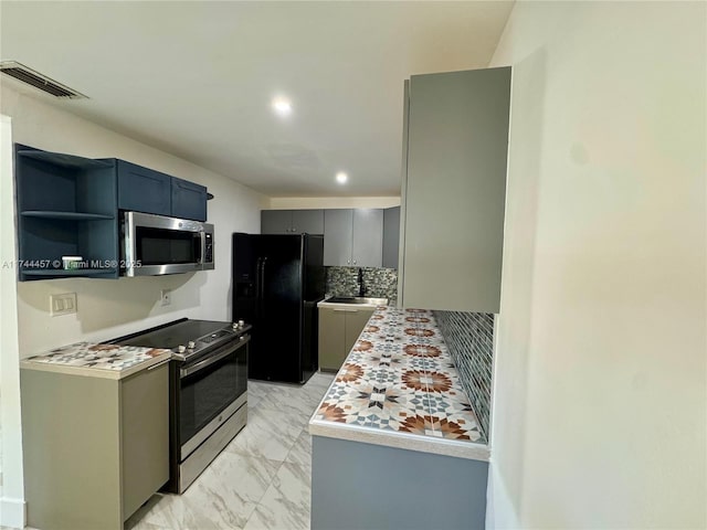 kitchen featuring marble finish floor, tasteful backsplash, light countertops, visible vents, and appliances with stainless steel finishes