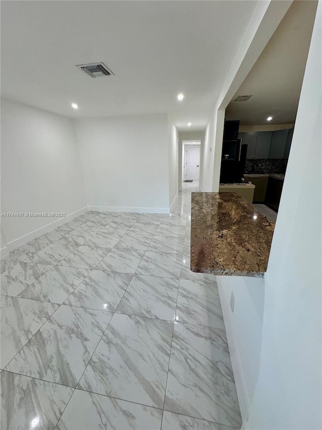 spare room with recessed lighting, marble finish floor, visible vents, and baseboards