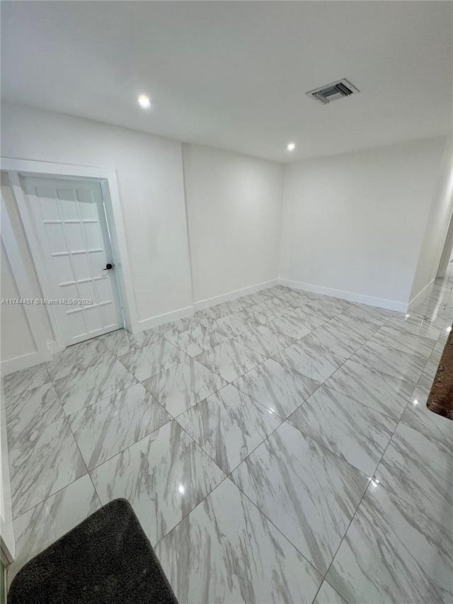 empty room featuring recessed lighting, marble finish floor, visible vents, and baseboards