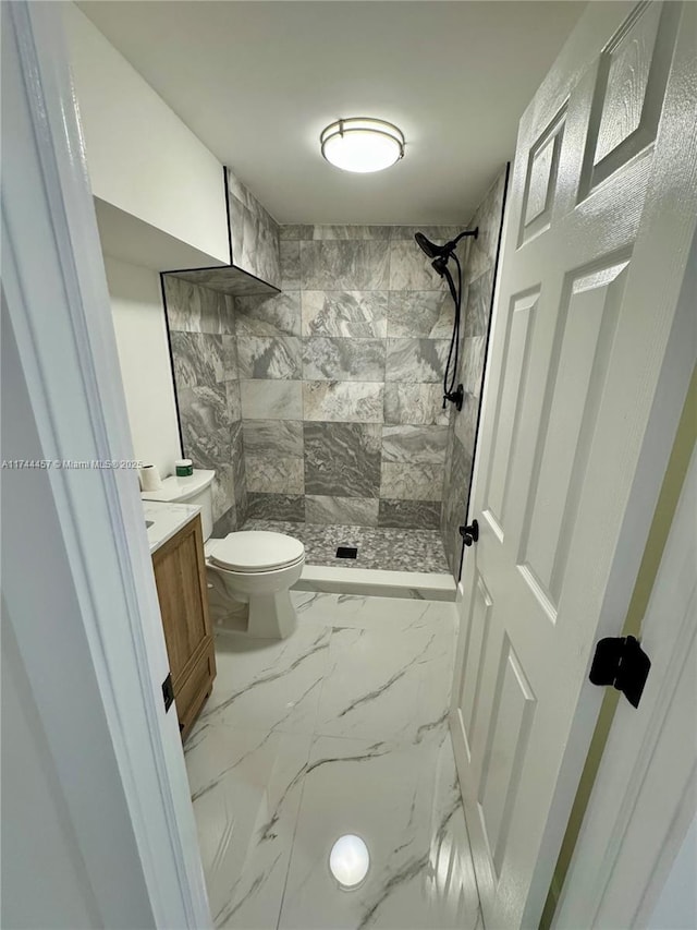 bathroom featuring a stall shower, marble finish floor, vanity, and toilet