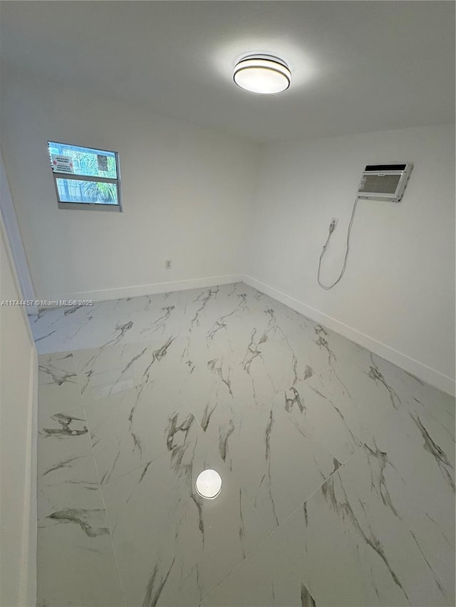 unfurnished room featuring marble finish floor and baseboards