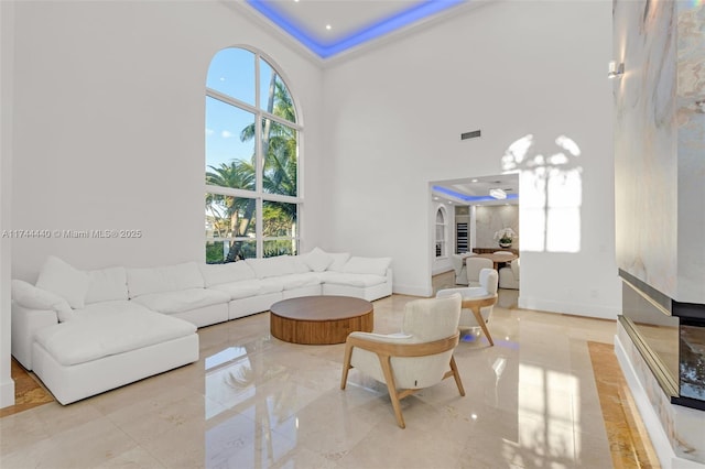 living room featuring a tray ceiling and a high ceiling