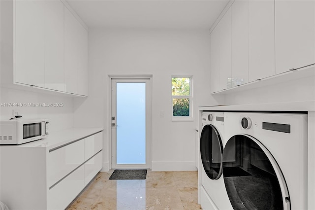 laundry area with washer and dryer and cabinets