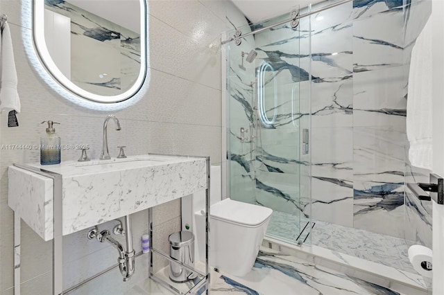 bathroom featuring walk in shower, vanity, toilet, and tile walls