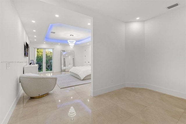 bedroom with french doors and a raised ceiling