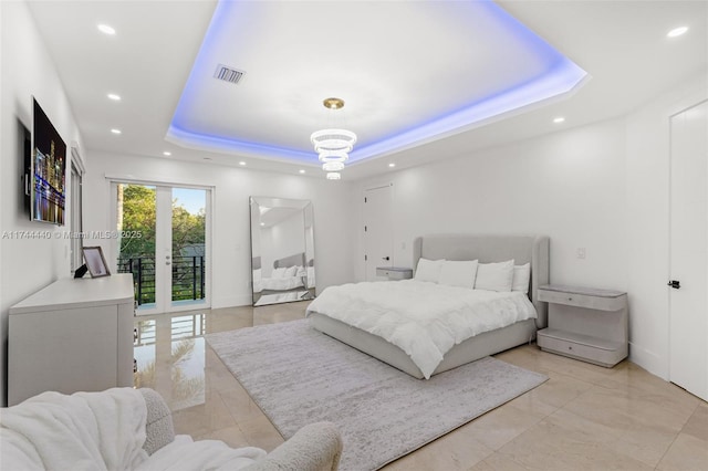 bedroom featuring a notable chandelier, a tray ceiling, and french doors