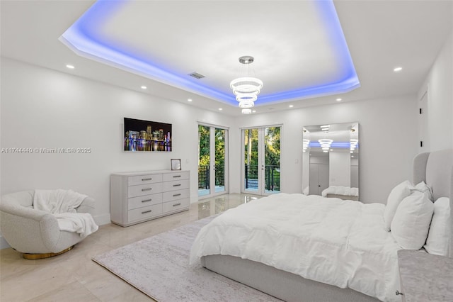 bedroom with access to exterior and a tray ceiling