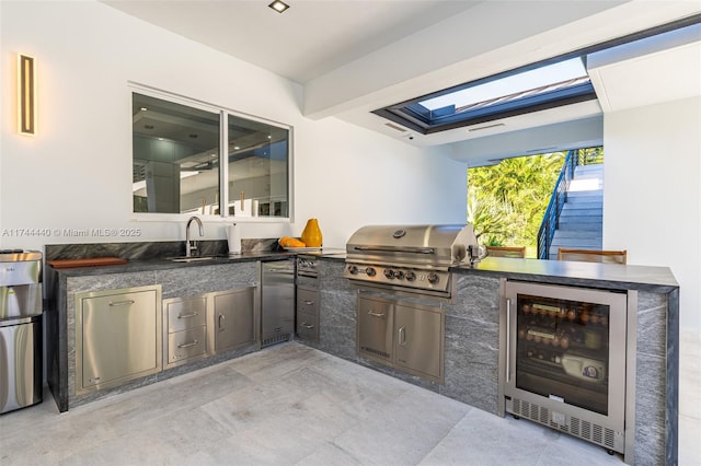 view of patio with wine cooler, sink, grilling area, and an outdoor kitchen