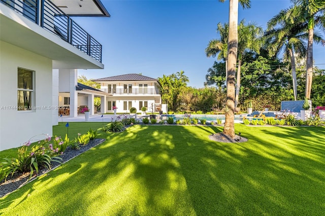 view of yard featuring a patio and a balcony