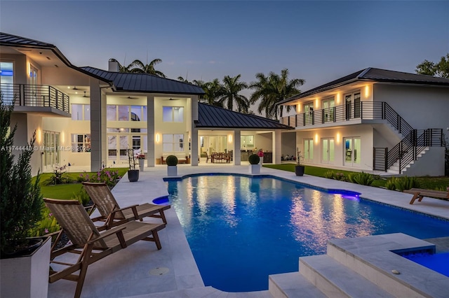 pool at dusk featuring a patio area