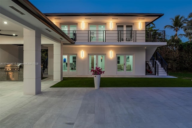 rear view of house featuring french doors, area for grilling, a balcony, and a patio