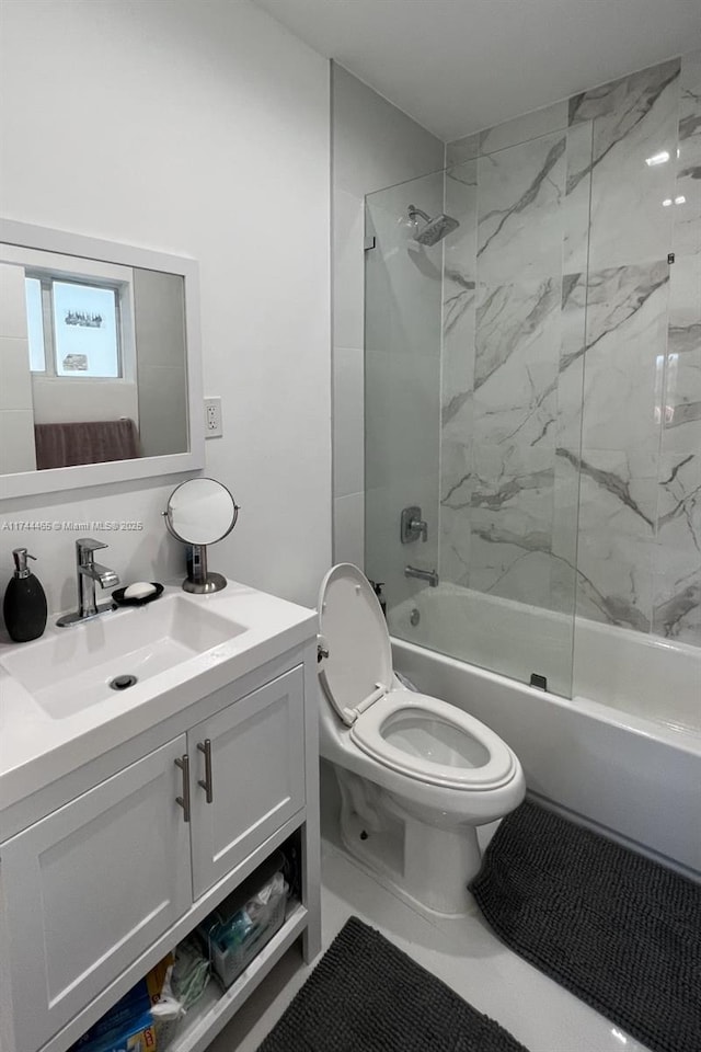 full bathroom featuring tiled shower / bath, vanity, and toilet