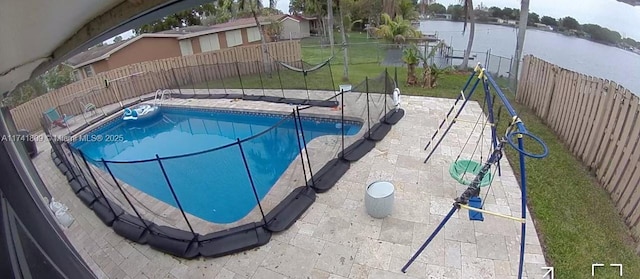 view of pool with a lawn and a water view