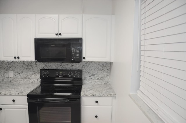 kitchen with tasteful backsplash, light stone counters, black appliances, and white cabinets