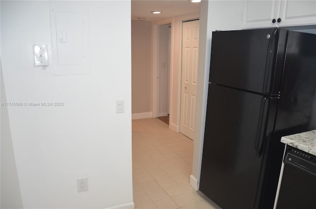 kitchen featuring electric panel, white cabinets, light stone counters, and black appliances