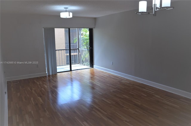 spare room featuring dark hardwood / wood-style floors and a textured ceiling