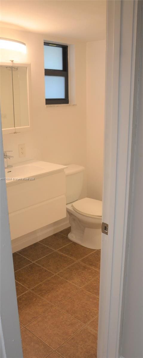 bathroom featuring vanity, tile patterned floors, and toilet