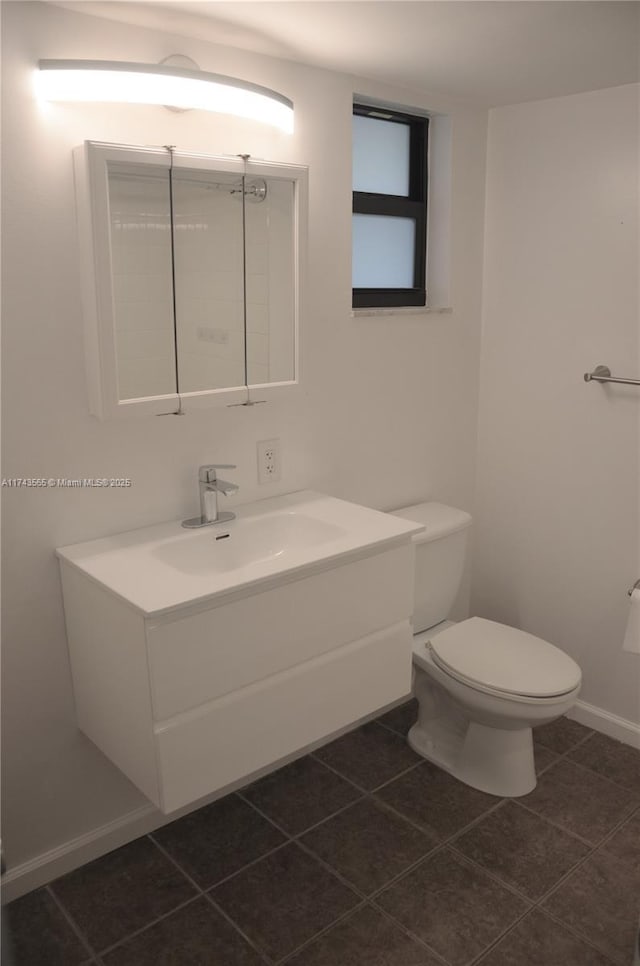 bathroom with tile patterned flooring, vanity, and toilet