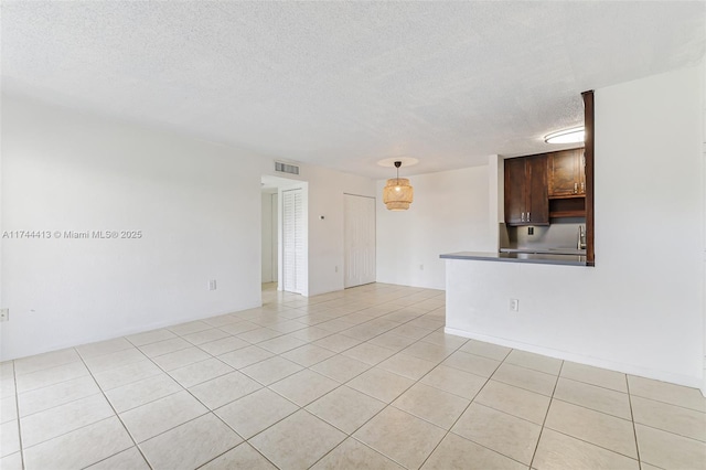 tiled empty room with sink and a textured ceiling