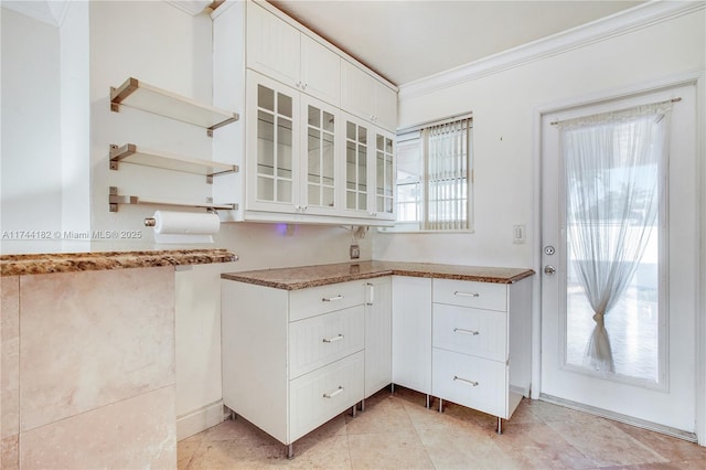 kitchen with white cabinetry, crown molding, and light tile patterned floors