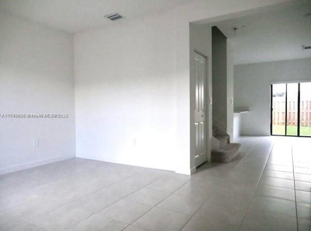 spare room featuring visible vents, stairway, and light tile patterned flooring