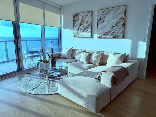 17001 Collins Ave Unit 2702, Sunny Isles Beach, FL 33160 - living room featuring healthy amount of natural light, wood finished floors, expansive windows, and a water view