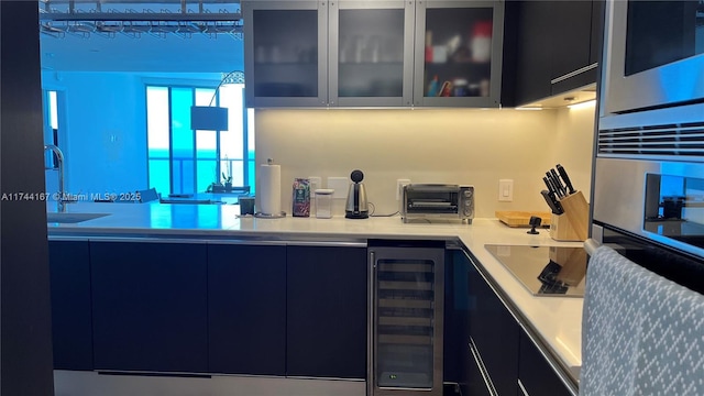 17001 Collins Ave Unit 2702, Sunny Isles Beach, FL 33160 - kitchen featuring modern cabinets, black electric cooktop, wine cooler, glass insert cabinets, and light countertops