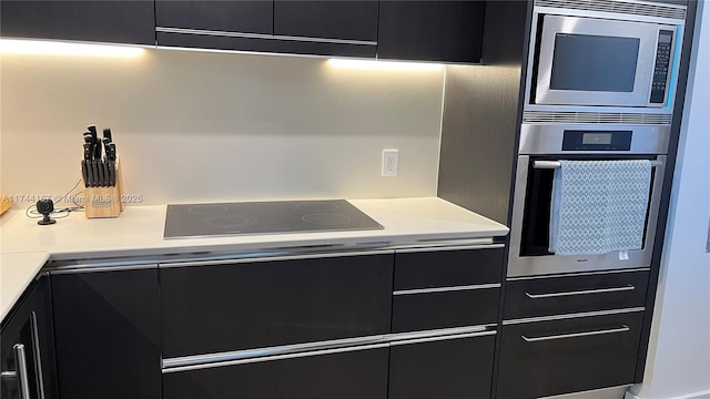 17001 Collins Ave Unit 2702, Sunny Isles Beach, FL 33160 - kitchen with appliances with stainless steel finishes, dark cabinetry, light countertops, and modern cabinets