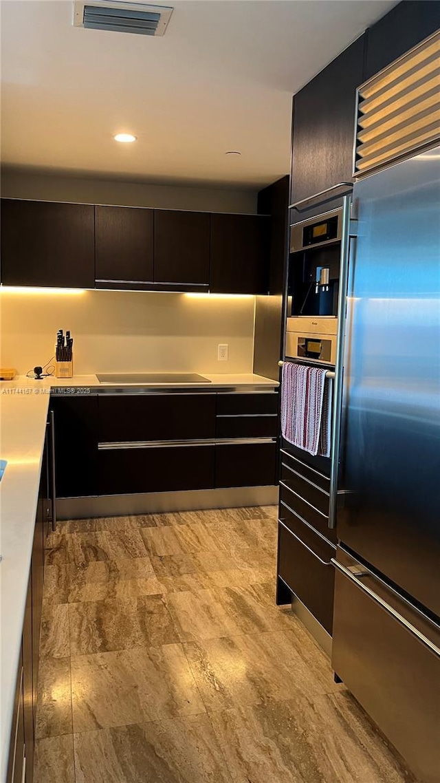17001 Collins Ave Unit 2702, Sunny Isles Beach, FL 33160 - kitchen featuring built in fridge, modern cabinets, dark cabinets, and light countertops