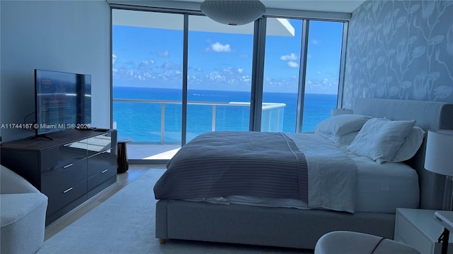 17001 Collins Ave Unit 2702, Sunny Isles Beach, FL 33160 - bedroom featuring multiple windows, a water view, expansive windows, and wallpapered walls