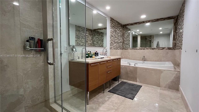 17001 Collins Ave Unit 2702, Sunny Isles Beach, FL 33160 - bathroom featuring a garden tub, double vanity, a shower stall, recessed lighting, and tile walls