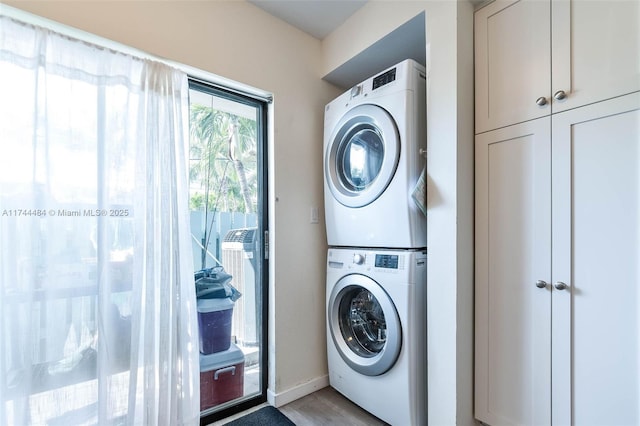 clothes washing area featuring stacked washing maching and dryer