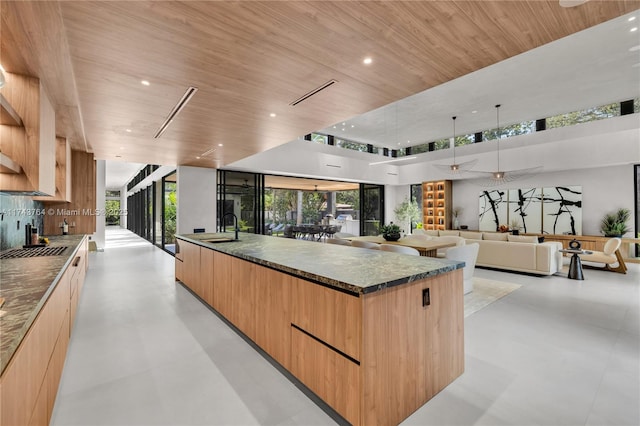 kitchen with a spacious island, sink, light brown cabinetry, and wooden ceiling