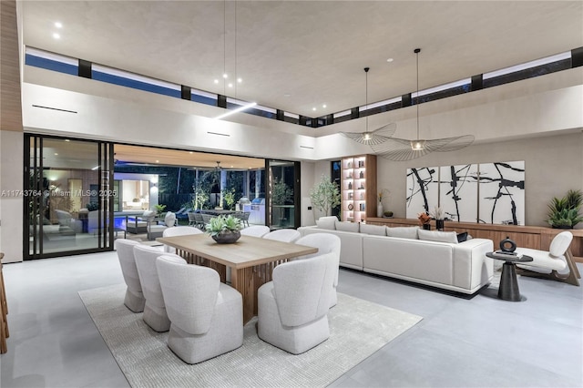 dining space featuring expansive windows and a towering ceiling