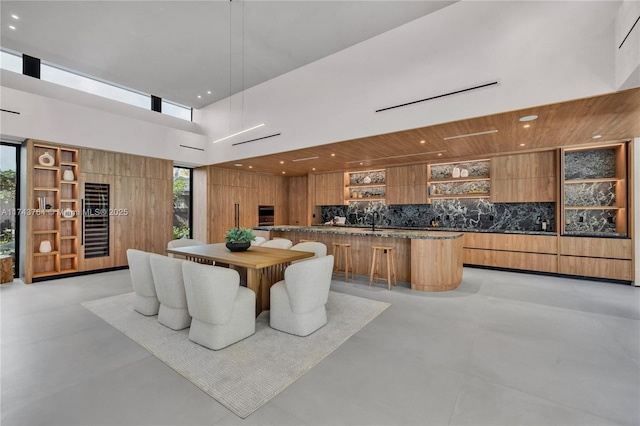 dining space featuring sink and a towering ceiling