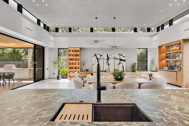 kitchen featuring sink, a towering ceiling, and pendant lighting