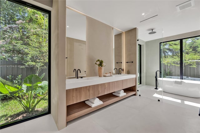 bathroom with plenty of natural light, vanity, and a bathing tub