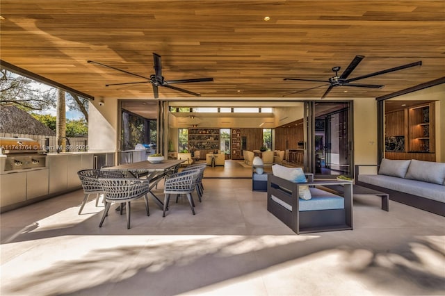 view of patio / terrace with ceiling fan, a grill, outdoor lounge area, and exterior kitchen