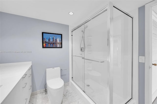 bathroom featuring vanity, toilet, and a shower with shower door