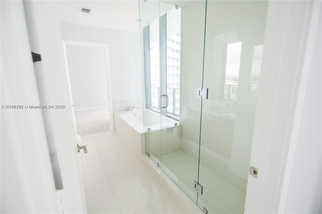 bathroom with tile patterned flooring, independent shower and bath, and toilet