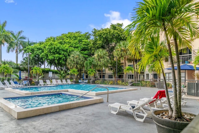 view of swimming pool with a patio area and a community hot tub