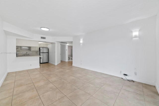 unfurnished living room featuring sink and light tile patterned floors