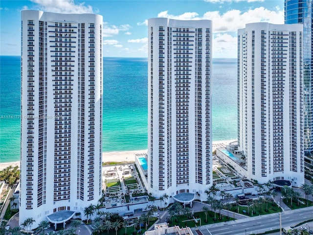 view of building exterior featuring a beach view and a water view