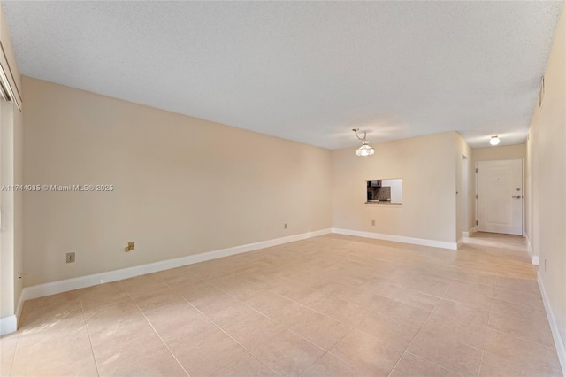 unfurnished room featuring a textured ceiling and light tile patterned floors