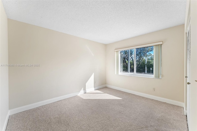 empty room with light carpet and a textured ceiling