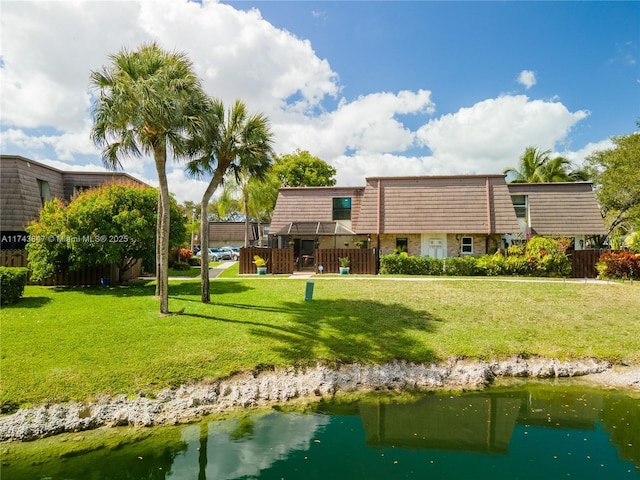 back of house featuring a yard and a water view