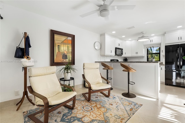 living area featuring light tile patterned flooring and ceiling fan